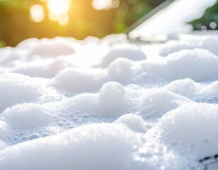 Close-up of sunlit soap suds on car surface in morning light