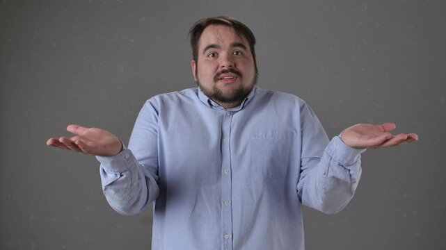Man in a Blue Shirt Shrugging with Hands Raised Expressively