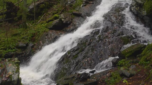 Stunning 4K aerial footage showcasing Belye Mosty Waterfall, Karelia's highest waterfall, cascading through lush forest and rugged rocks in Russia's wilderness.