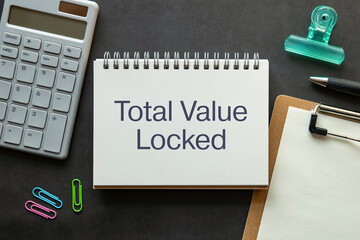 There is notebook with the word Total Value Locked. It is as an eye-catching image.