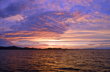Vibrant purple and orange sunset over the Adriatic Sea in Zadar, Croatia with dramatic cloudscape