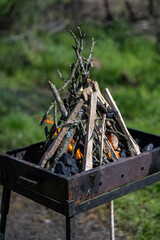 The old barbecue grill is set up in a country yard . Barbecue grill with smoke. Barbecue on the...