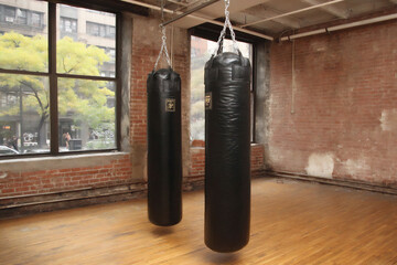 an interior photograph of a boxing training space features aged red brick walls as the backdrop