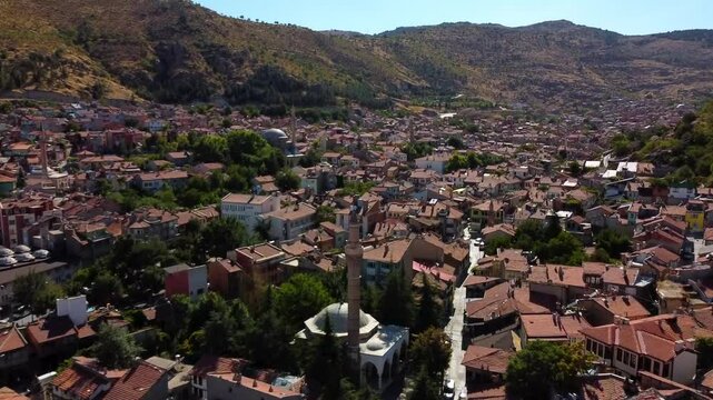 Aerial Tilt Up Shot Of The Afyon Grand Mosque Amidst Houses Amidst Mountains Against Clear Sky, Drone Flying Forward On Sunny Day - Afyonkarahisar, T�rkiye