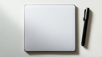 Blank writing tablet and black marker pen on white surface