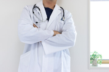 腕組みして考え事をする医者のイメージ（日本人、男性、顔無し、30代）