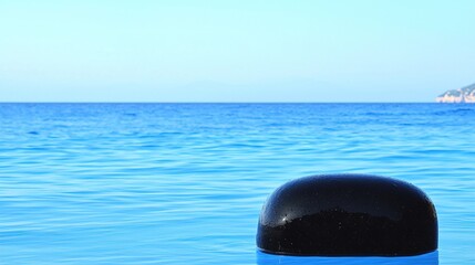 Plakat Black stone with calm sea, and island view.