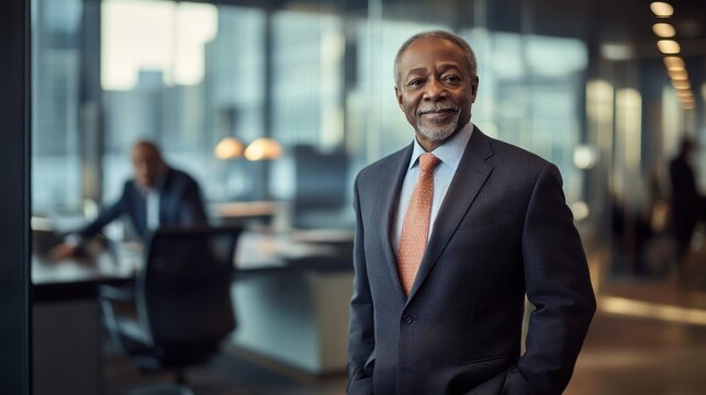 A confident senior African American businessman poses in an elegant office setting, showcasing professionalism and leadership in a modern corporate environment.