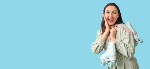 Surprised young woman with roller skates on light blue background with space for text