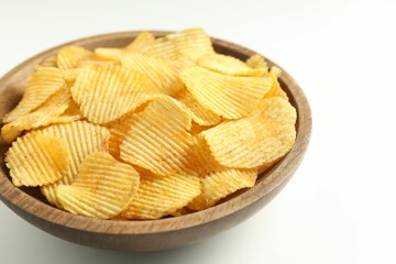 Tasty potato chips in bowl on white background, closeup