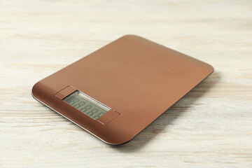 Modern electronic kitchen scale on wooden table, closeup