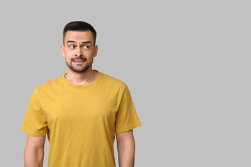 Obraz premium Handsome worried young man on grey background