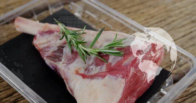 Bone-in meat cut being displayed on black tray with rosemary inside container on kitchen surface