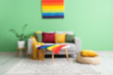 Interior of living room with sofa, painting and LGBT flag on table