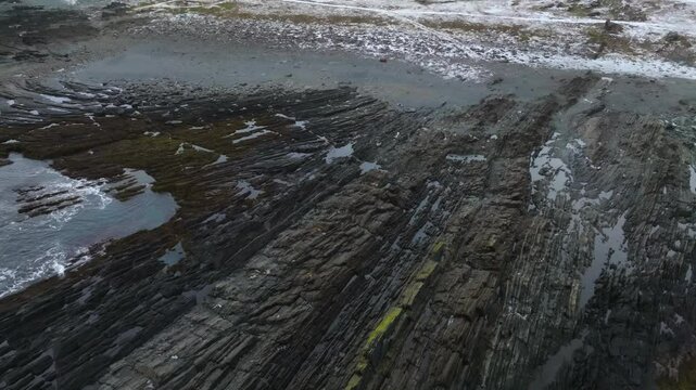 Aerial view of flysch formations, showcasing rhythmic layering of sedimentary rock shaped by geological and marine forces