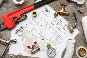 Set of plumber's items with house plan on grey grunge background