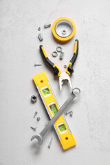 Spirit level and construction tools on white grunge background