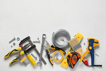 Fototapeta premium Wires and construction tools on white grunge background