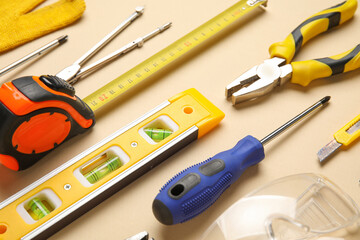 Arrangement of different construction tools on beige background