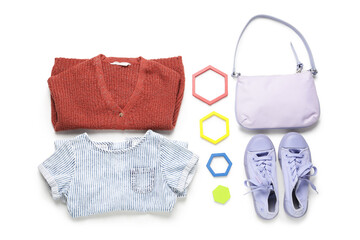 Stylish children's clothes with toys on white background