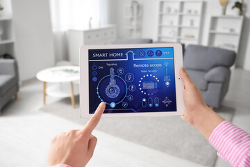 Female hands using tablet with smart home security system control panel in room