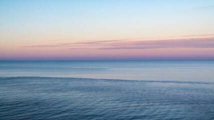 Fototapeta premium Calm ocean under a beautiful pastel sky at twilight or dawn