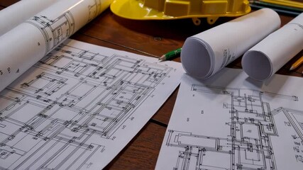 Architectural blueprint review with safety gear and drafting tools on wooden desk