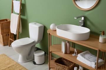 Interior of restroom with toilet bowl, sink and ladder