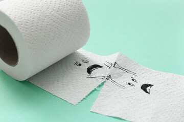 Toilet paper roll with drawn funny faces on color background, closeup. Friendship Day celebration