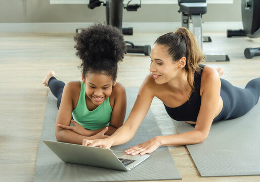 Single mother woman and child daughter 2 person body slim smile relax fun enjoy look labtop coach teacher training student exercise balance yoga sport gym fitness class room with love care happy time