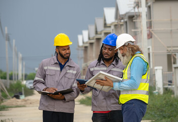 Fototapeta premium Professional architect and foreman wear head hat talk meeting safety work team check inspection tablet document ergy sorlar panels improvement project plan design home building in construction site.
