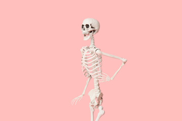 Scary human skeleton running on pink background