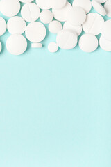 Many white pills on blue background