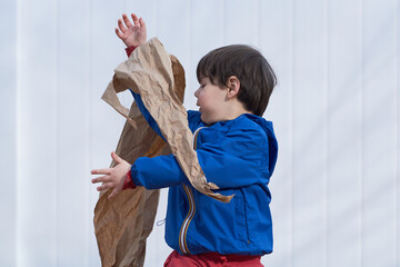 young boy playing with paper