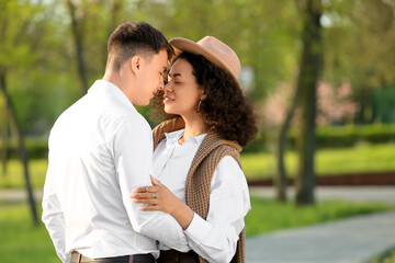 Obraz premium Beautiful young happy couple touching noses in park on spring day