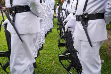 Soldiers in White Ceremonial Uniforms Standing in Formation with Rifles