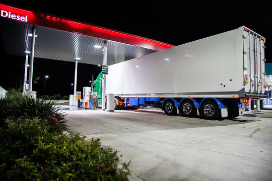 Truck filling up with Diesel petrol at service station at night