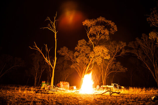 Campfire burning in a clearing in a farm paddock