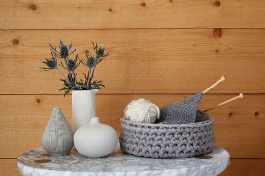 Marble coffee or bedside table with flowers, vases and knitting