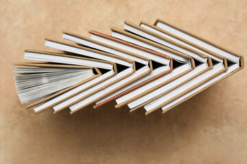 Many different half open books on beige grunge background