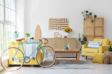 Interior of living room with bicycle, yellow sofa and armchair