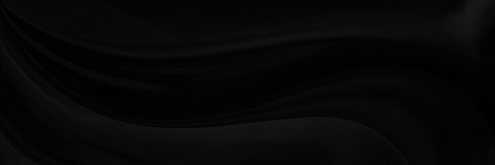 Black gray satin dark fabric texture luxurious shiny that is abstract silk cloth panorama background with patterns soft waves blur beautiful.
