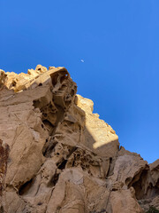 Jagged Rocks and the Moon Against Blue Sky in Cabo San Lucas