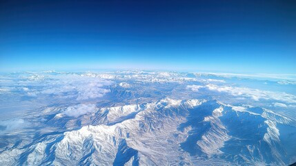 Aerial View of a Snow Covered Mountain Range Under a Clear Blue Sky