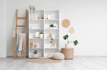 Interior of light room with shelf unit, ladder and plants