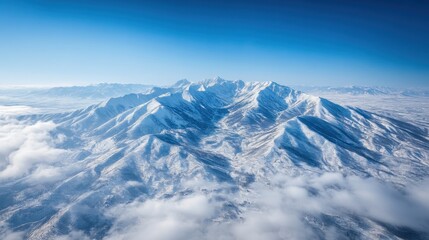 Aerial View of Snow Covered Mountain Range Under a Bright Blue Sky