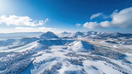 Obraz premium Aerial View of Snow Covered Mountain Range Under Blue Sky