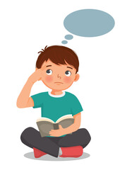 Little boy reading book thinking day dreaming sitting on floor