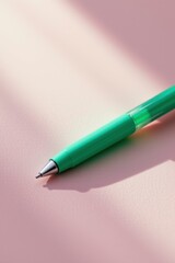 Fototapeta premium Mint Green Pen on Pink Background with Soft Lighting