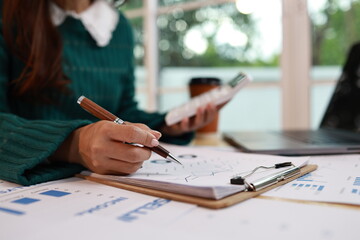 A professional woman wearing a headset works at her desk in a modern office, communicating with a...